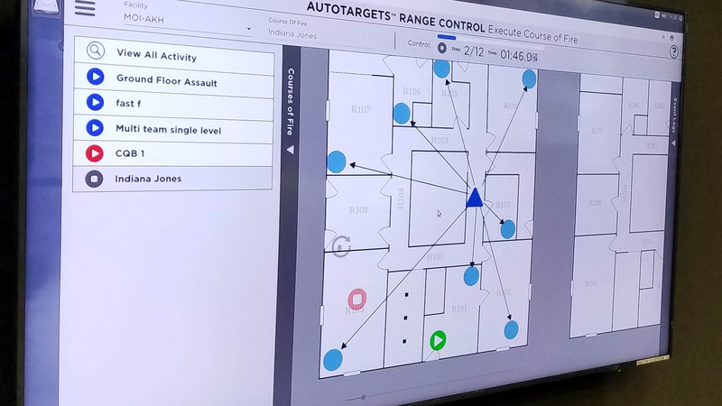 Range Control course-of-fire execution screen on a large wall display, showing a shoot house floor plan with target positions and a step timer.